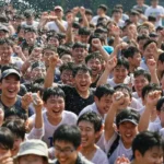 한국 민속촌 여름 축제에서 단체 물놀이 프로그램에 참여하는 사람들의 활기찬 모습입니다.