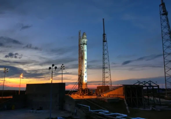Solid rocket installed on metal launch construction in spaceport and ready for taking off against colorful sunset sky